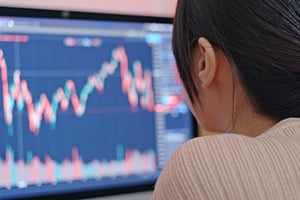 Woman looking at her computer screen assessing the market outlook