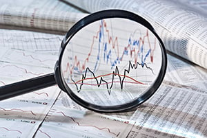 magnifying glass examining market volatility